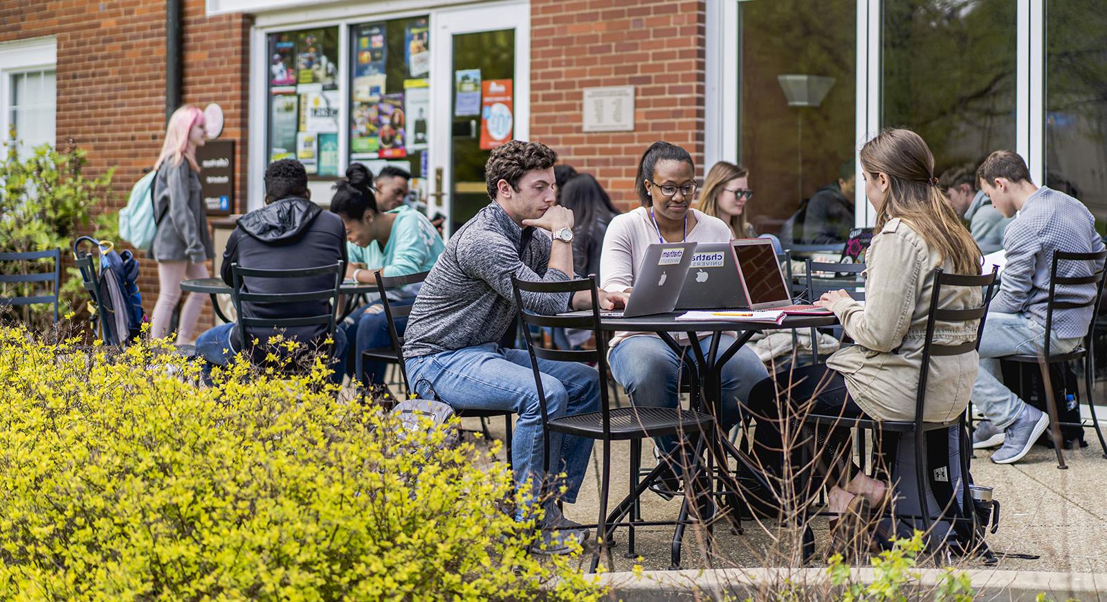 Photo of Chatham University students working on outdoor patio tables in front of Cafe Rachel on the 足球波胆平台.